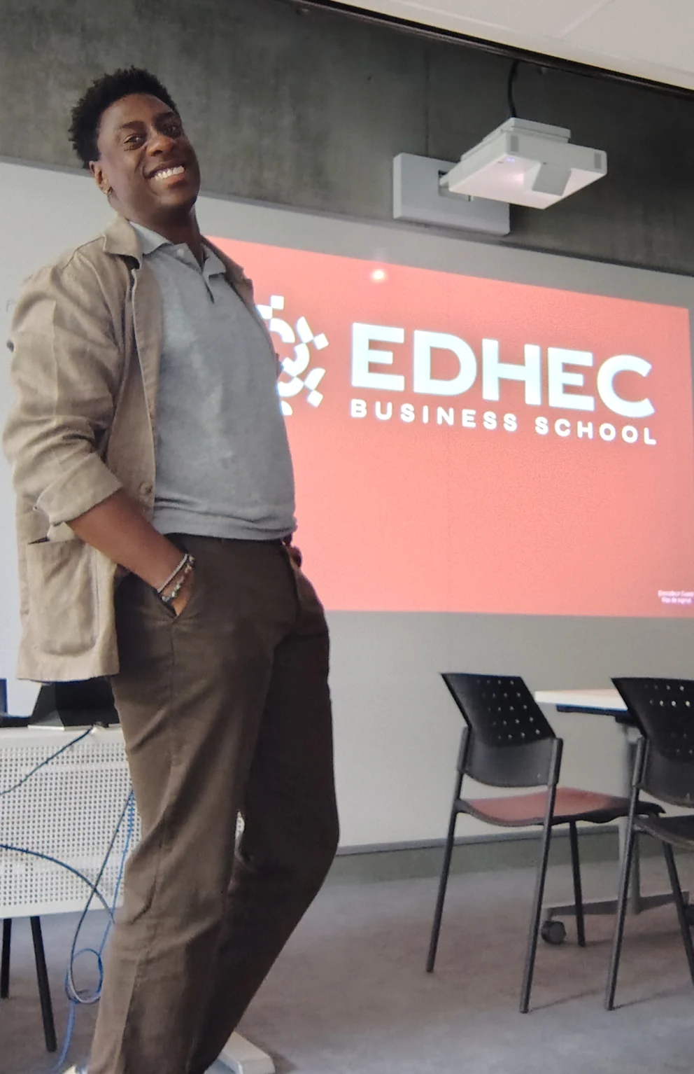 Lilian Barty-Christophe souriant, en intervention devant un écran affichant le logo EDHEC Business School